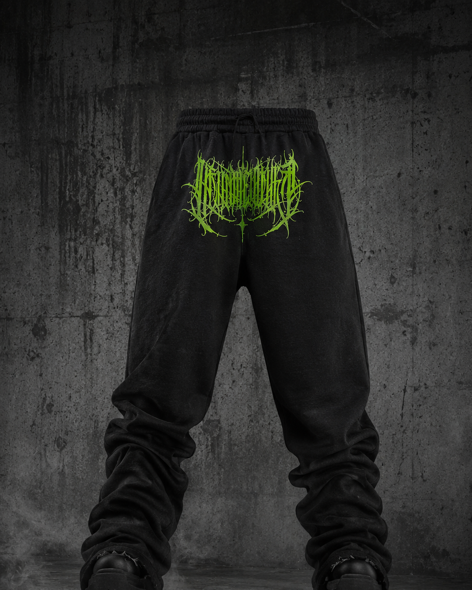 Black sweatpants with gothic greendark calligraphy logo on a textured gray background