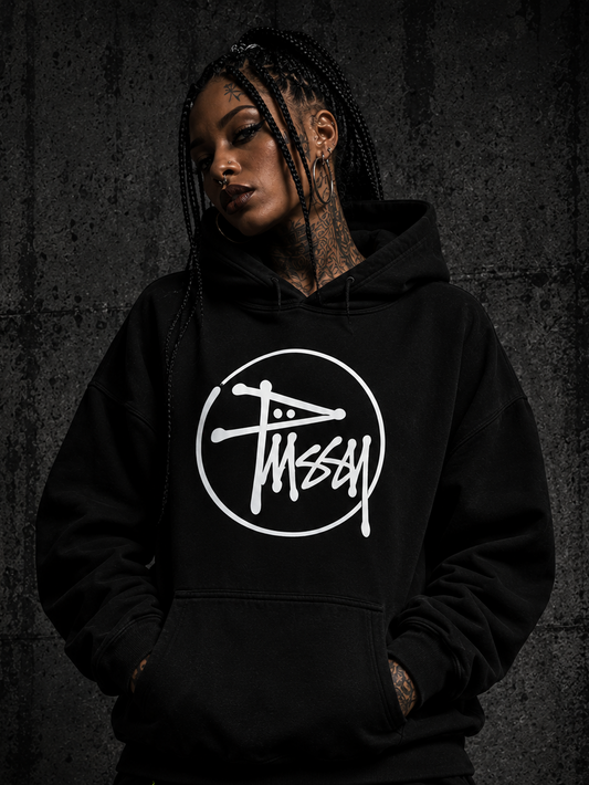 A tattooed model wearing a black pussy sweatshirt, with a dark textured background.